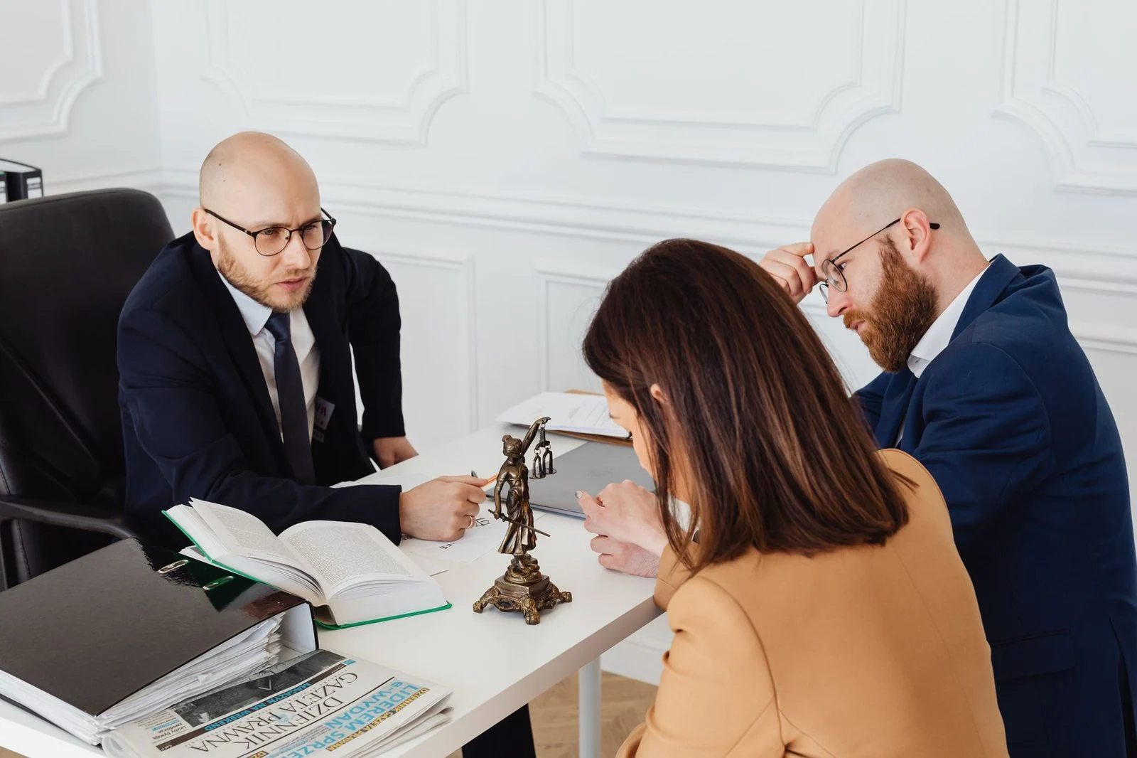A lawyer in a modern office meets with clients for a serious discussion about cancellation of removal in Florida.